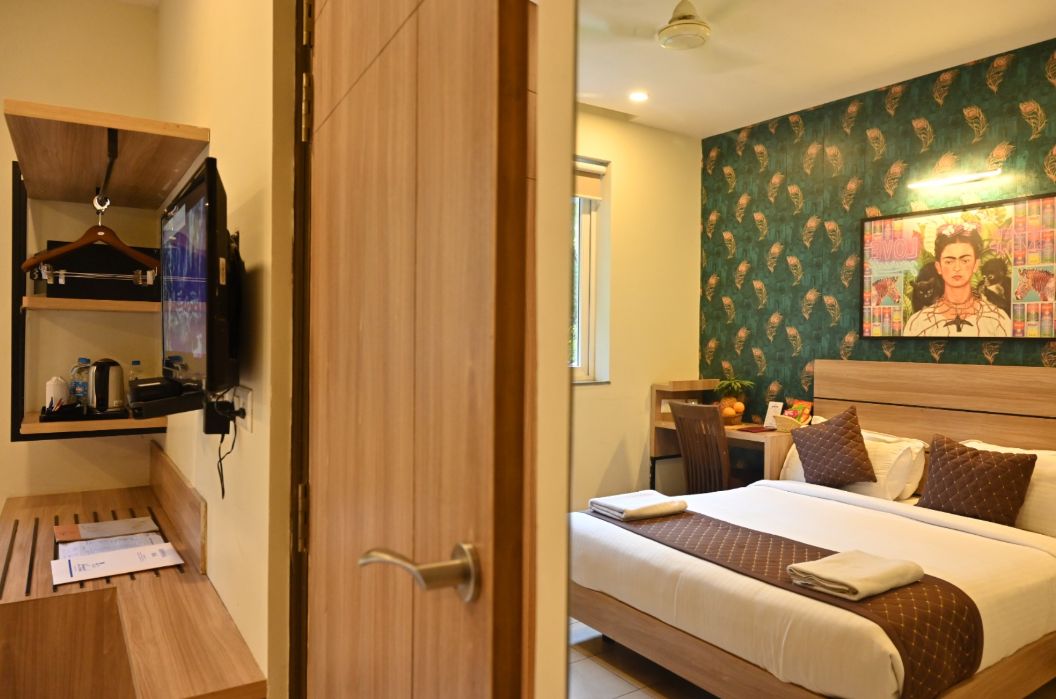 Een hotelkamer met een bed, een bureau, een stoel en een televisie.