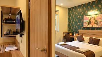 Een hotelkamer met een bed, een bureau, een stoel en een televisie.
