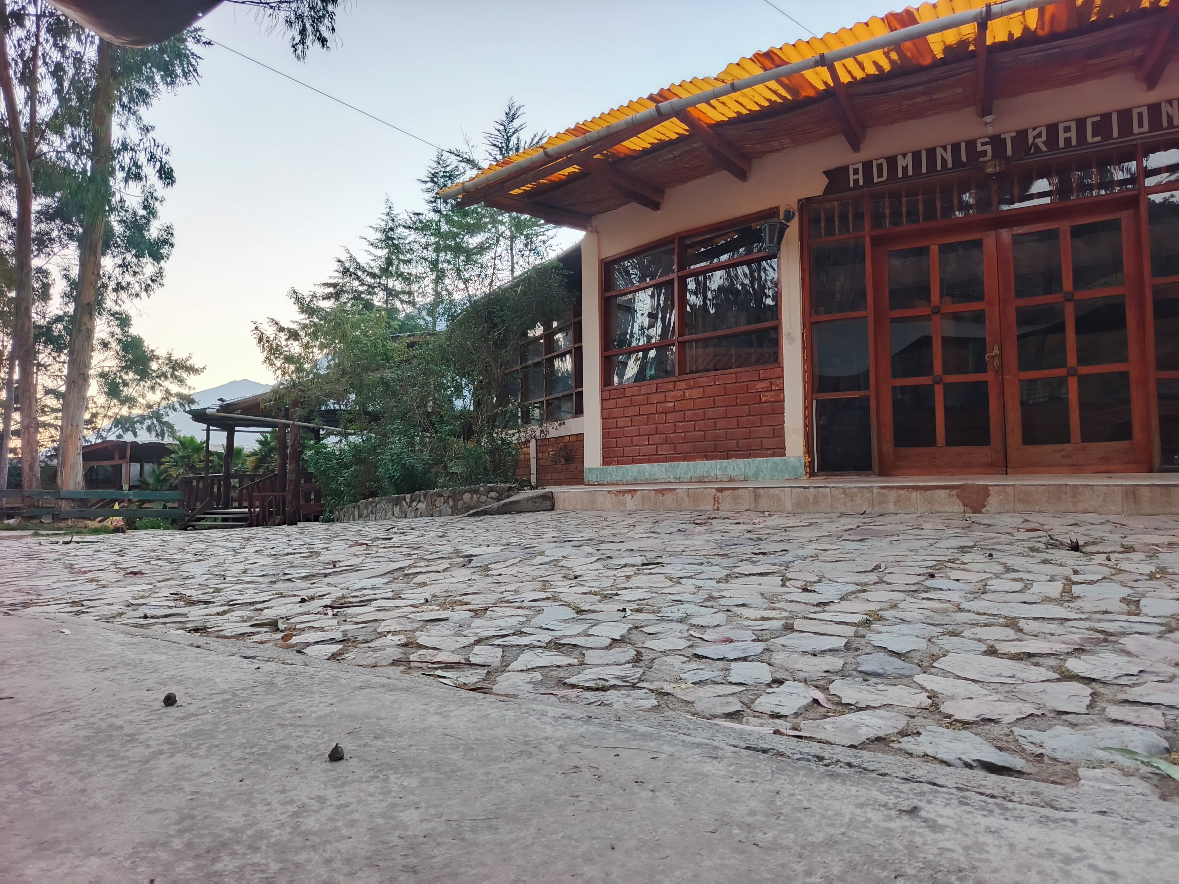 A building with a sign reading 'DOMINISTRACION' and a stone-paved area in front.