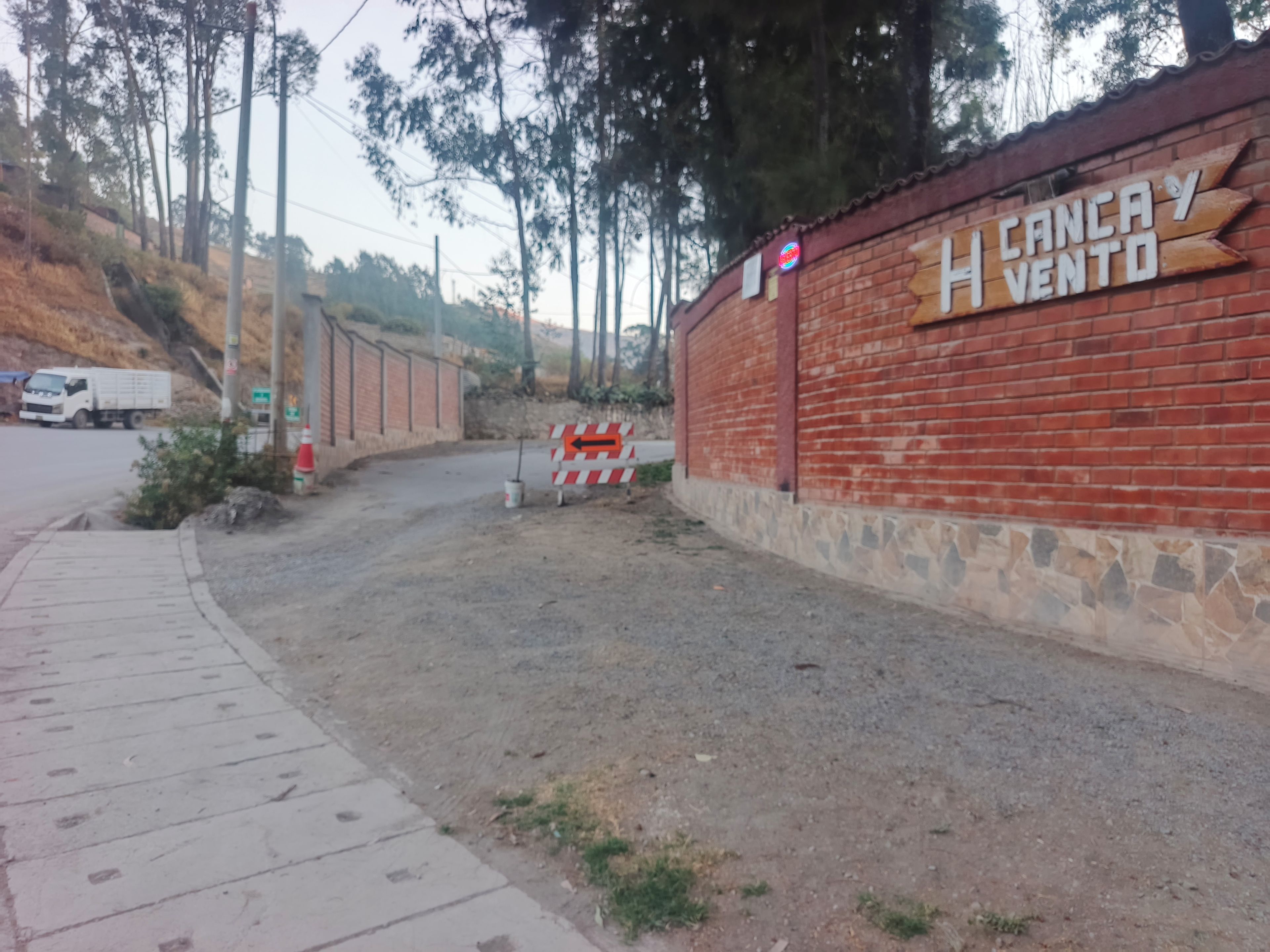 A construction site with a brick wall and a sign that reads 'CANCAY VENTO'.