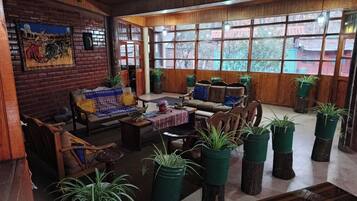Una habitación con mural de ladrillos, muebles de madera y ventanas grandes.