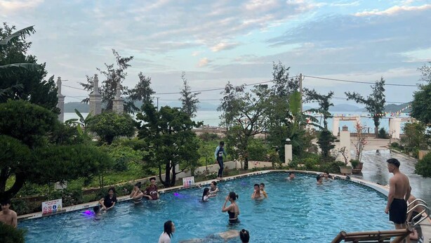 Ein Pool, umgeben von Bäumen, mit Blick auf eine ferne Stadtlandschaft.