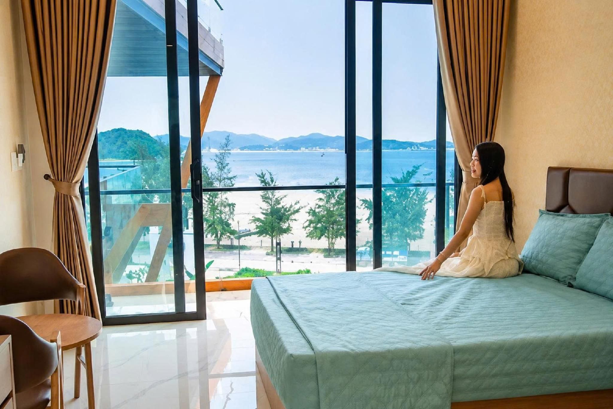 Un dormitorio con una cama grande, vista al mar y un balcón.