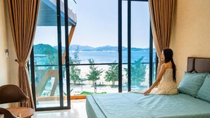 Ein Schlafzimmer mit einem großen Bett, Meerblick und einem Balkon.