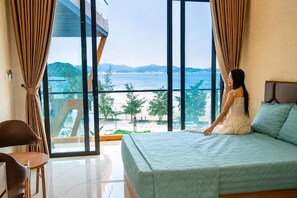 Ein Schlafzimmer mit einem großen Bett, Meerblick und einem Balkon.