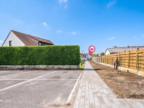 A parking lot with a paved walkway leading to a building with a red-tiled roof. - Ter Heide I with terrace & parking by Interhome (Westende-Bad)