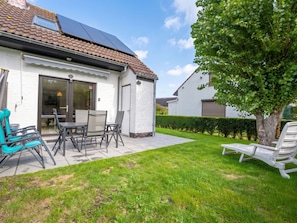 A residential property with a patio area, outdoor seating, and a solar panel on the roof. - Ter Heide I with terrace & parking by Interhome (Westende-Bad)