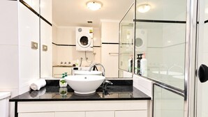 A modern bathroom with a white sink, a glass shower enclosure, and a built-in washing machine. - The Ember | 2BR|2BA|Pool, Gym, Sauna + Parking | Boutique Stay near Sydney CBD (Waterloo)