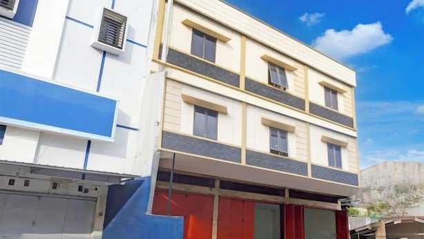 Un immeuble à plusieurs étages, doté d’une façade sobre, de grandes fenêtres et d’un espace d’entrée abrité.