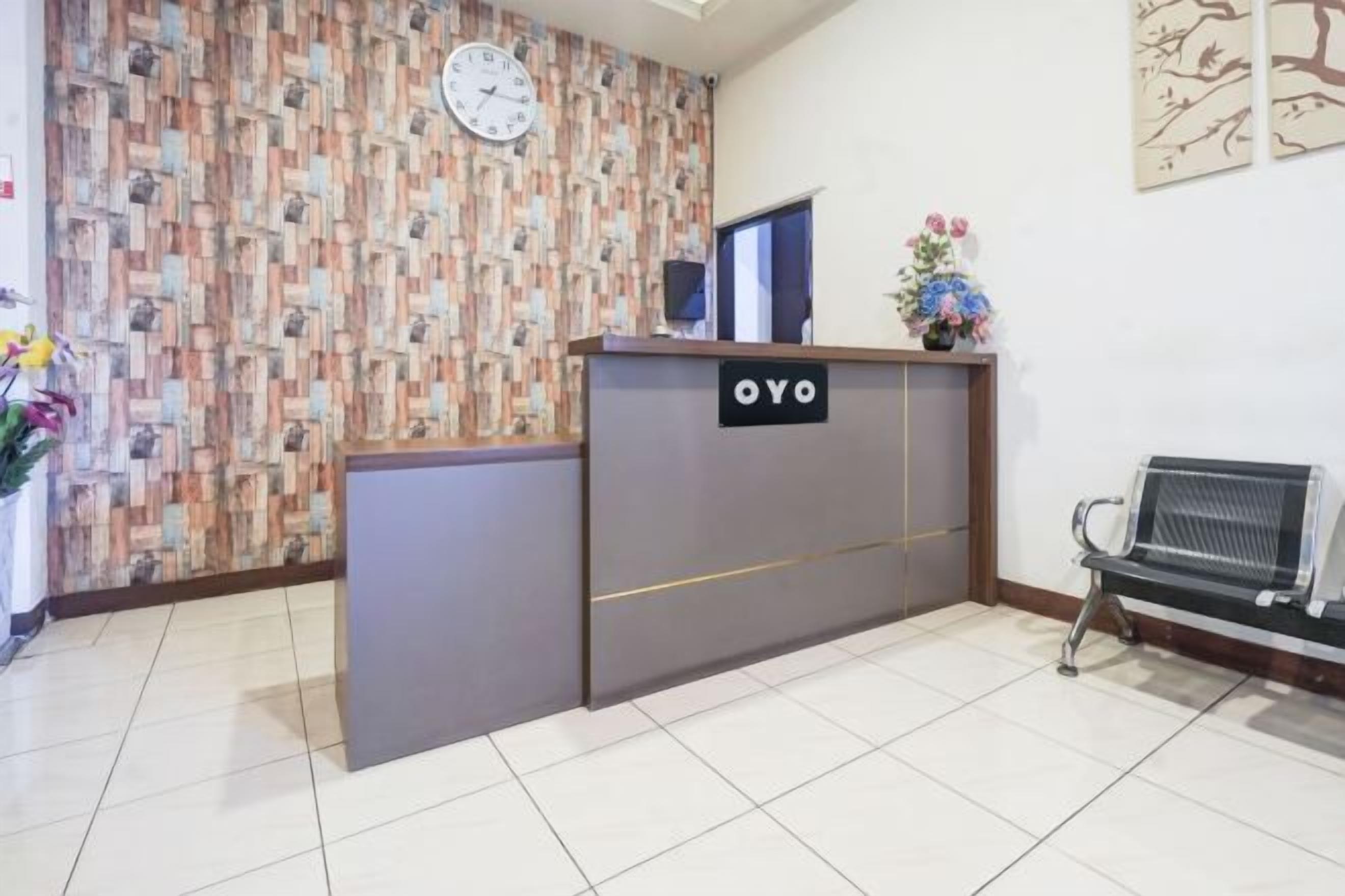 A reception area with a reception desk, a clock, and a bench.