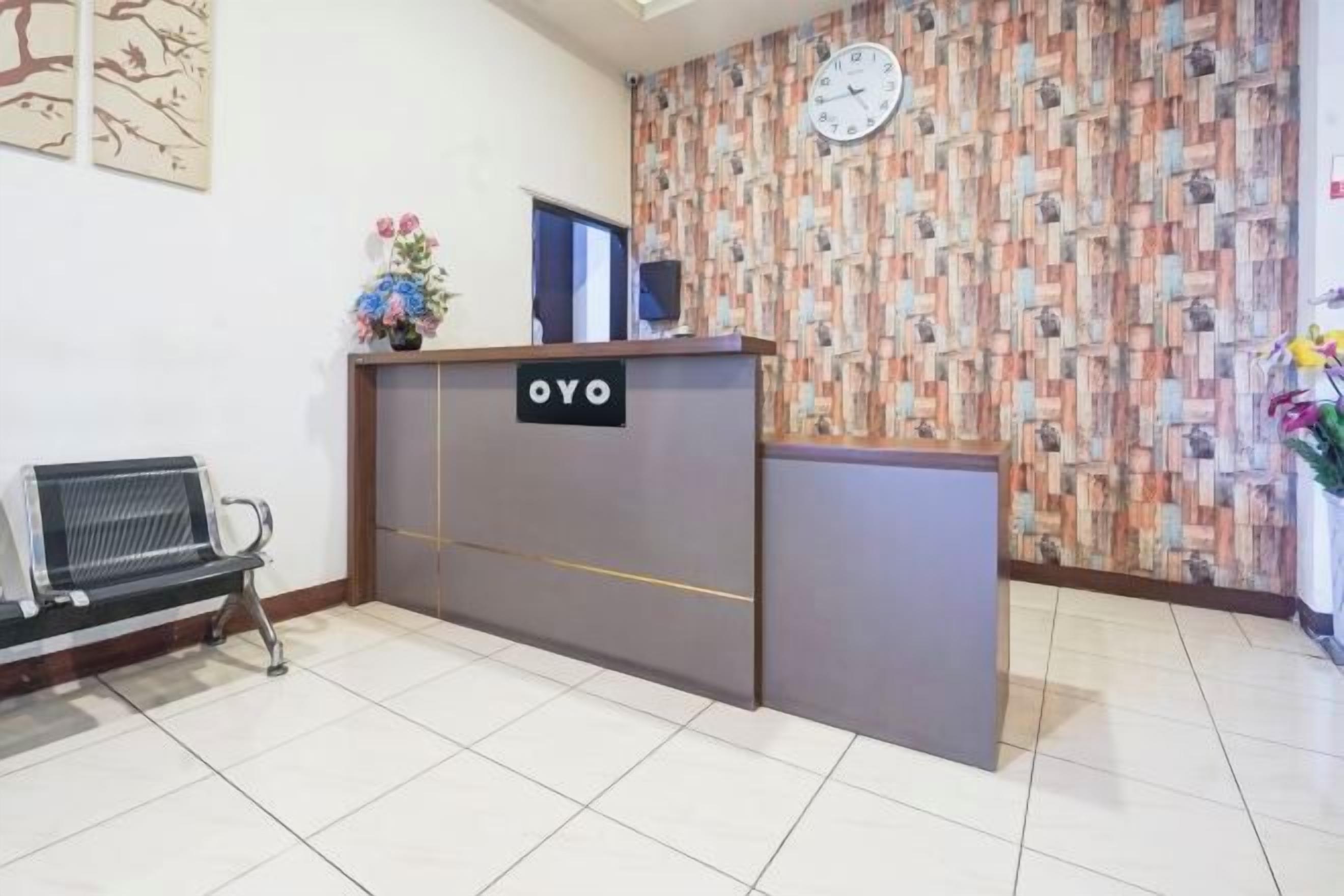 Una recepción con un letrero, un reloj y un papel tapiz estampado.