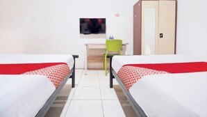Une chambre avec deux lits, un bureau, une chaise, une télévision et une armoire.