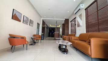 Un interior moderno con un sofá, sillas, una mesa de centro y obras de arte en las paredes.