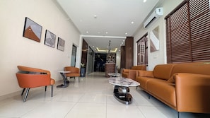 A modern interior with a sofa, chairs, a coffee table, and artwork on the walls.