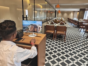 Un vestíbulo de hotel con una pantalla grande que muestra una vista panorámica, una recepción y un suelo con diseño.