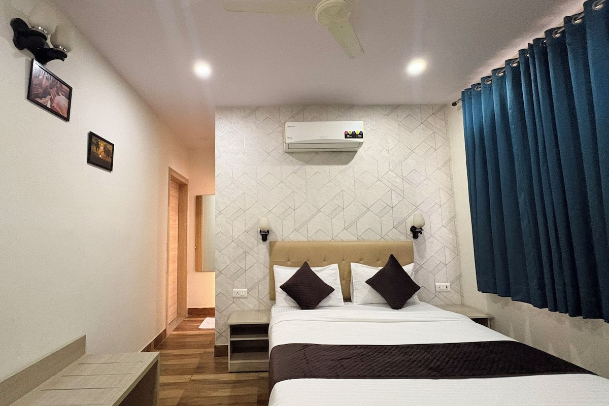 Ein Hotelzimmer mit einem Bett, einem Telefon, einer Klimaanlage und einer Treppe zu einem anderen Raum.