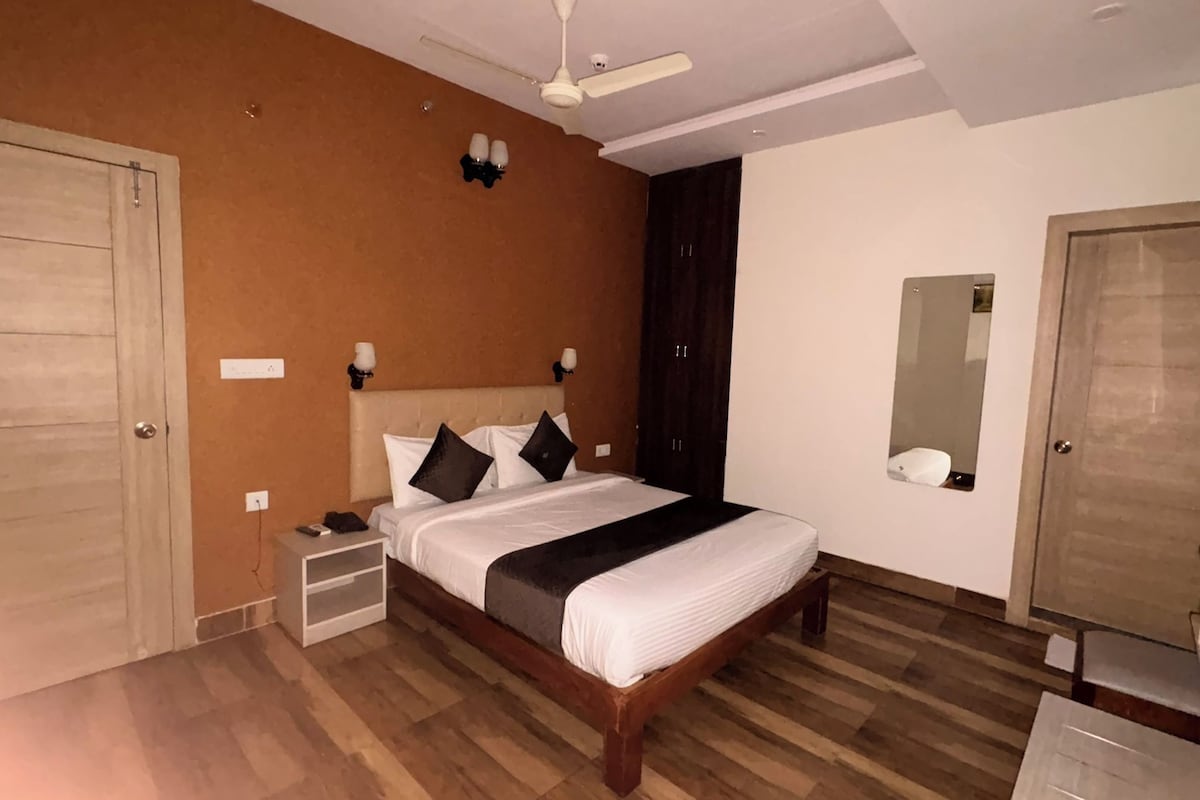Een slaapkamer met een bed, nachtkastjes, een spiegel en een kledingkast.
