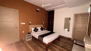 Een slaapkamer met een bed, nachtkastjes, een spiegel en een kledingkast.