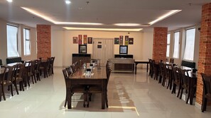 A conference room with a long table, chairs, a television, and motivational posters on the wall.