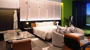 Una habitación de hotel moderna con cama, zona de estar y televisor.