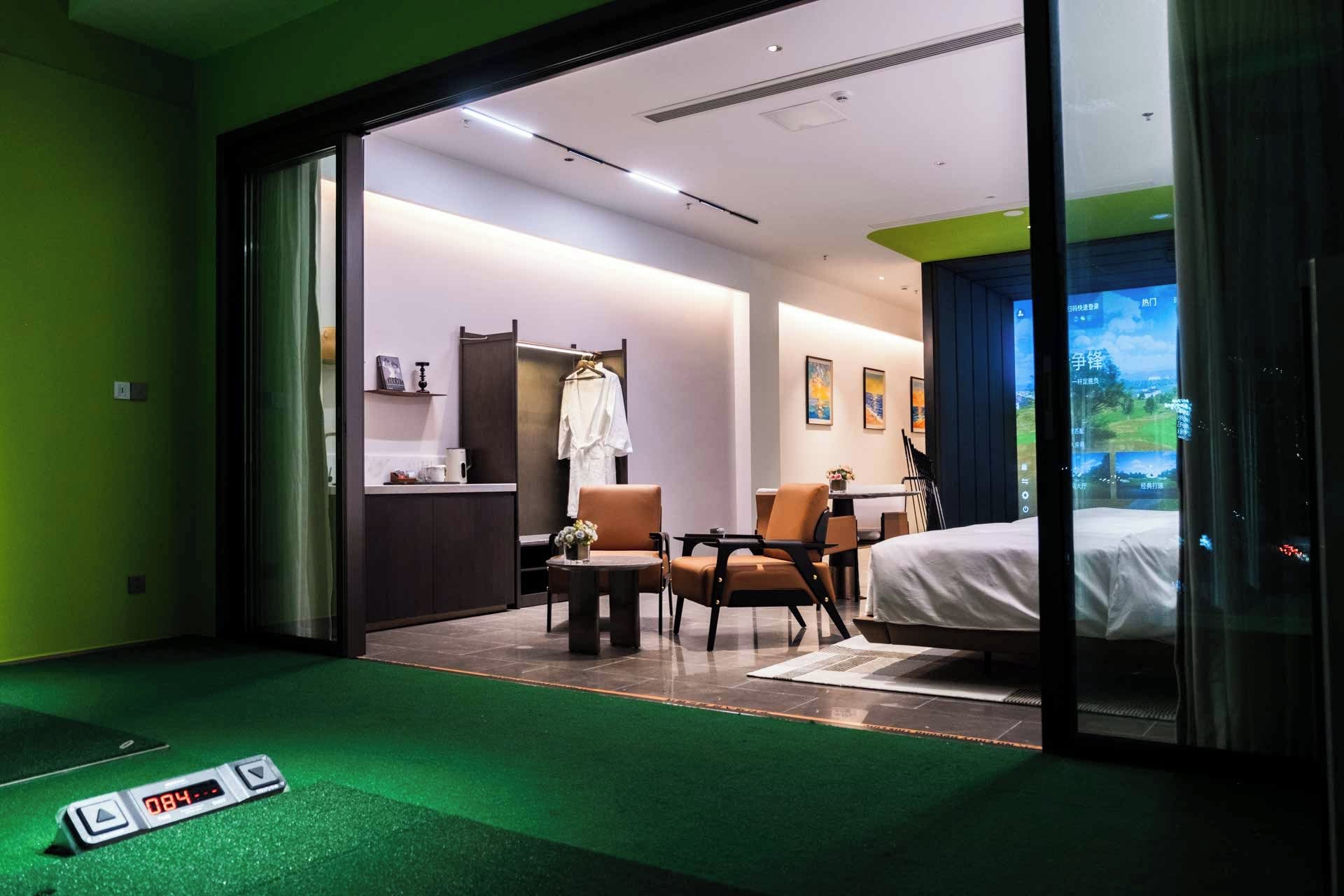 Habitación de hotel con cama, escritorio, silla, armario y vistas al exterior.