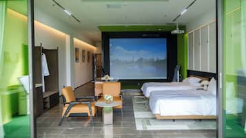 Una habitación de hotel con una cama, un escritorio, una silla y una televisión que muestra una vista urbana.