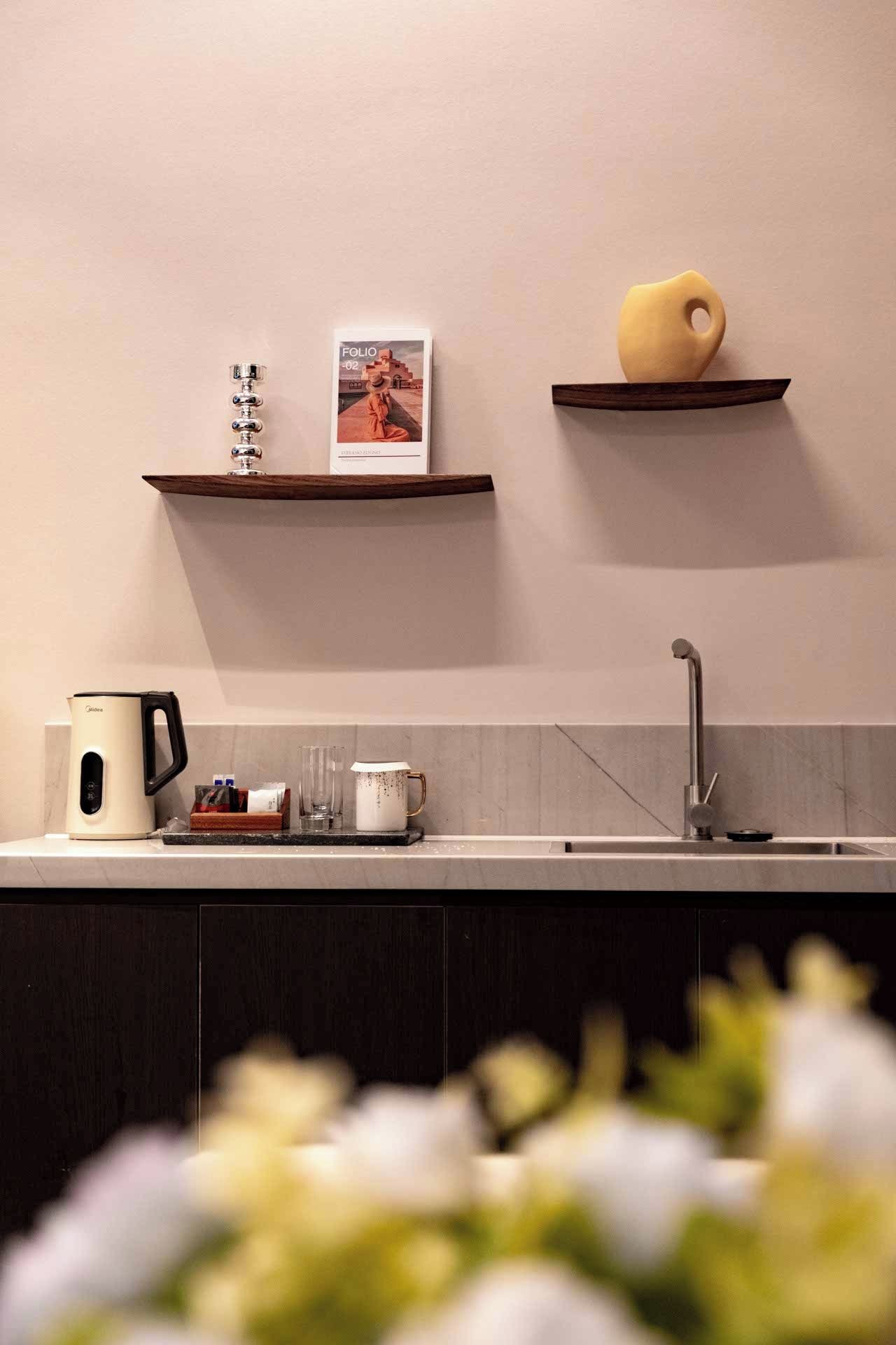 Una cocina moderna con una cafetera, una taza y una revista sobre la encimera.