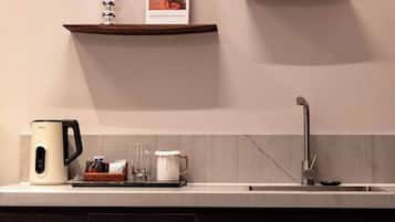Una cocina moderna con una cafetera, una taza y una revista sobre la encimera.