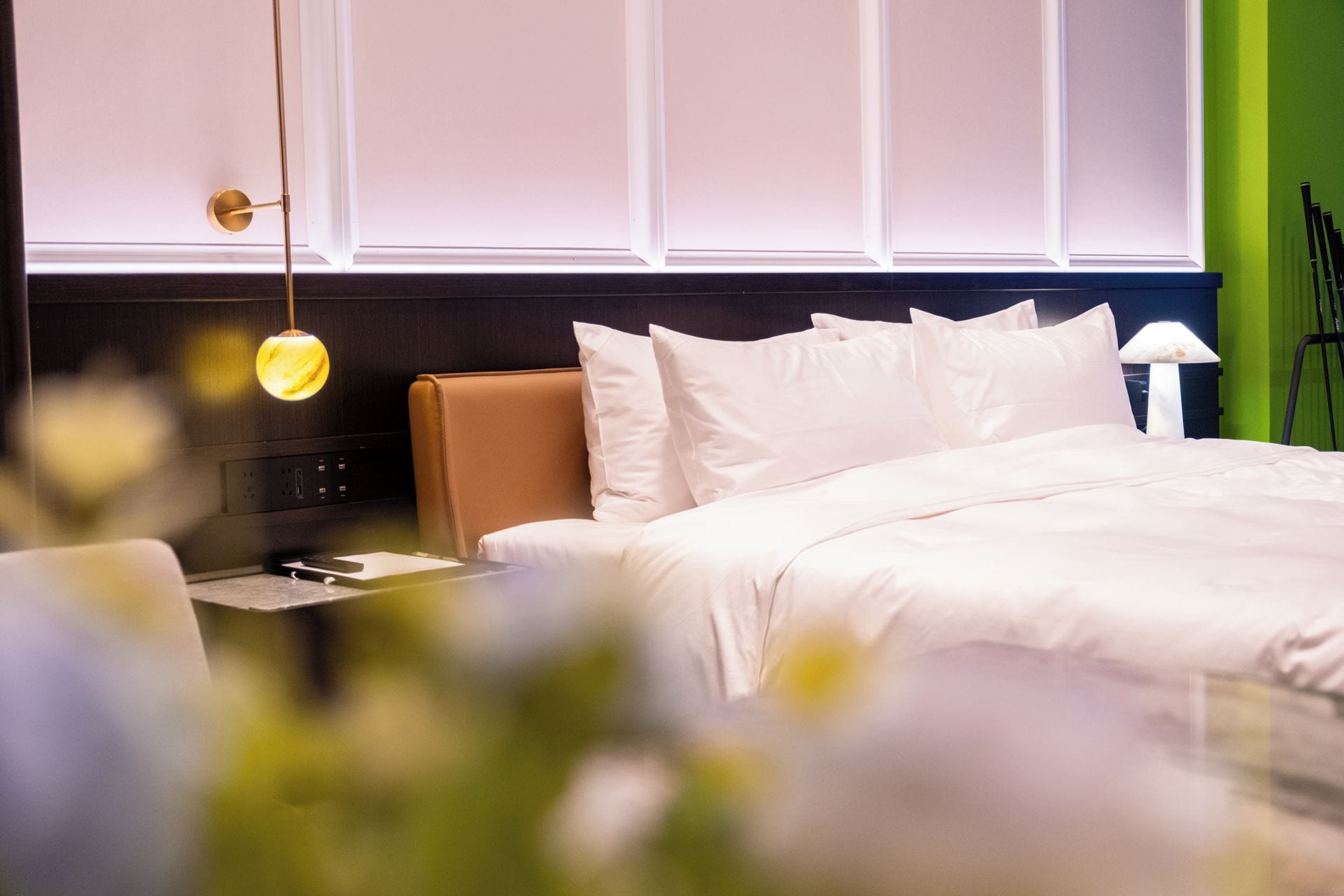 Une chambre d’hôtel avec un lit, une table de chevet et une lampe.