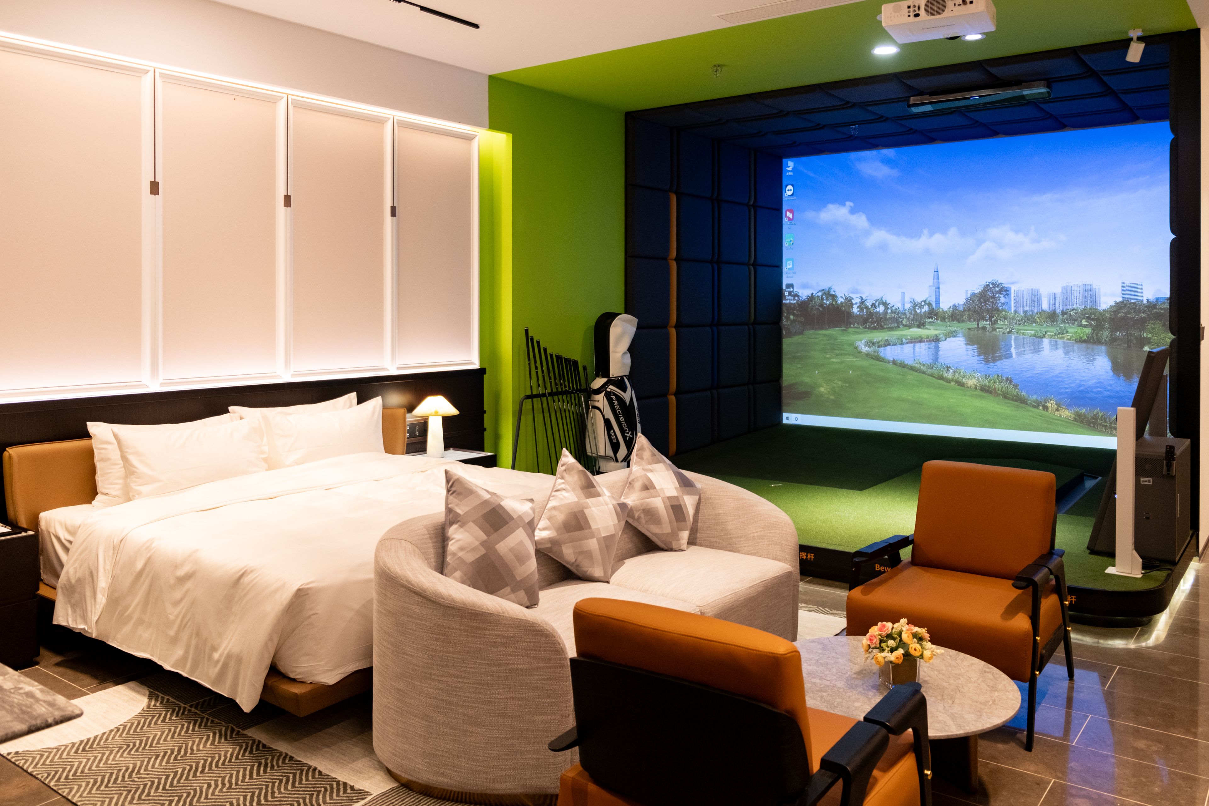 Une chambre d’hôtel comprenant un lit, un canapé, une chaise, une petite table et un écran de télévision diffusant une vue sur la ville.