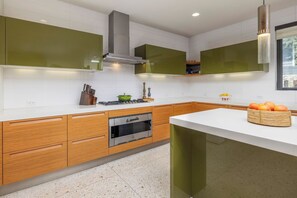 Eine moderne Küche mit Holzausstattung, einem Einbauofen und einer weißen Arbeitsplatte.