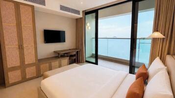 Une chambre d’hôtel avec un lit, une télévision, un bureau et un balcon offrant une vue.
