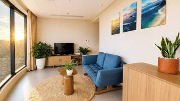 Un salon moderne avec un canapé, un téléviseur et des plantes en pot.