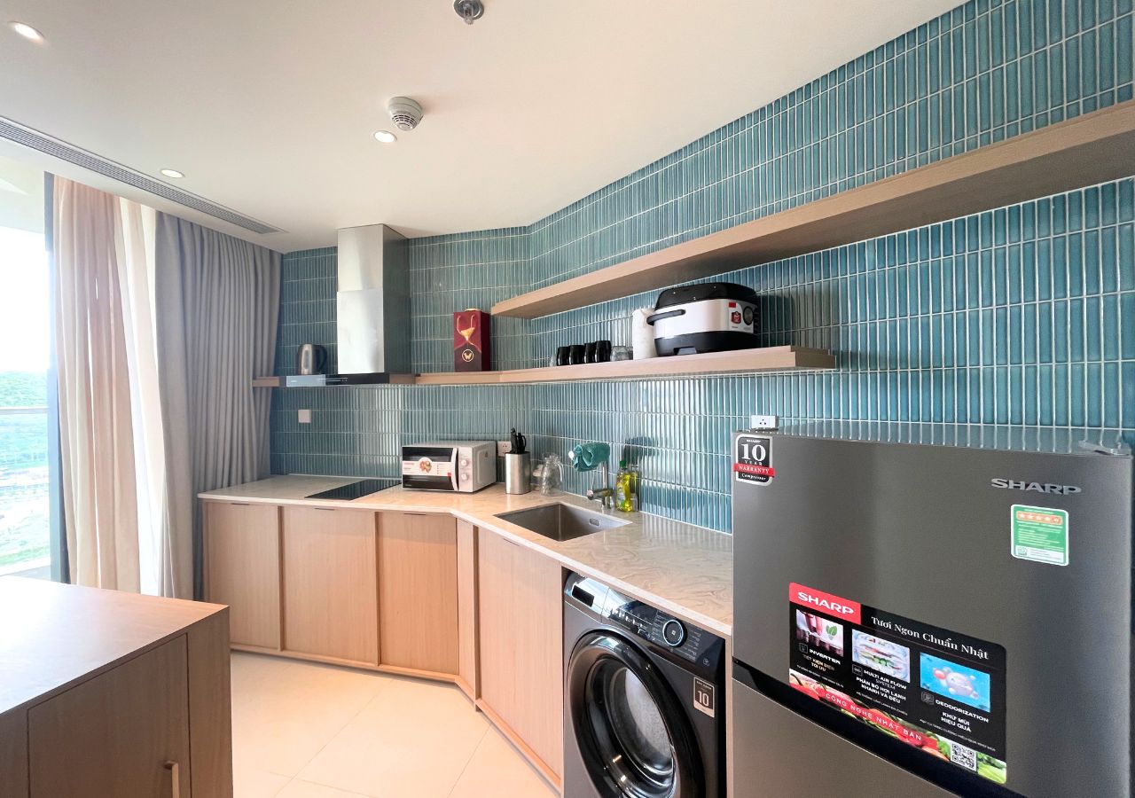 Una cocina compacta con lavadora, refrigerador y microondas.