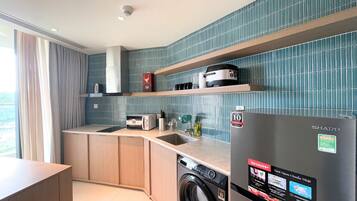 Una cocina compacta con lavadora, refrigerador y microondas.