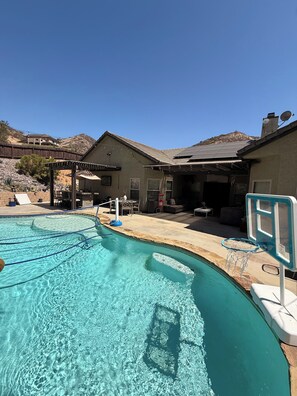 A swimming pool with a basketball hoop, a covered patio area, and a mountain backdrop. - Relax & Play Near Sycuan Casino Resort Sleeps 12 (El Cajon)