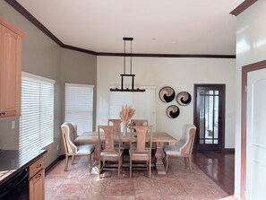 A dining area with a wooden table and chairs, a chandelier, and wall art. - Relax & Play Near Sycuan Casino Resort Sleeps 12 (El Cajon)