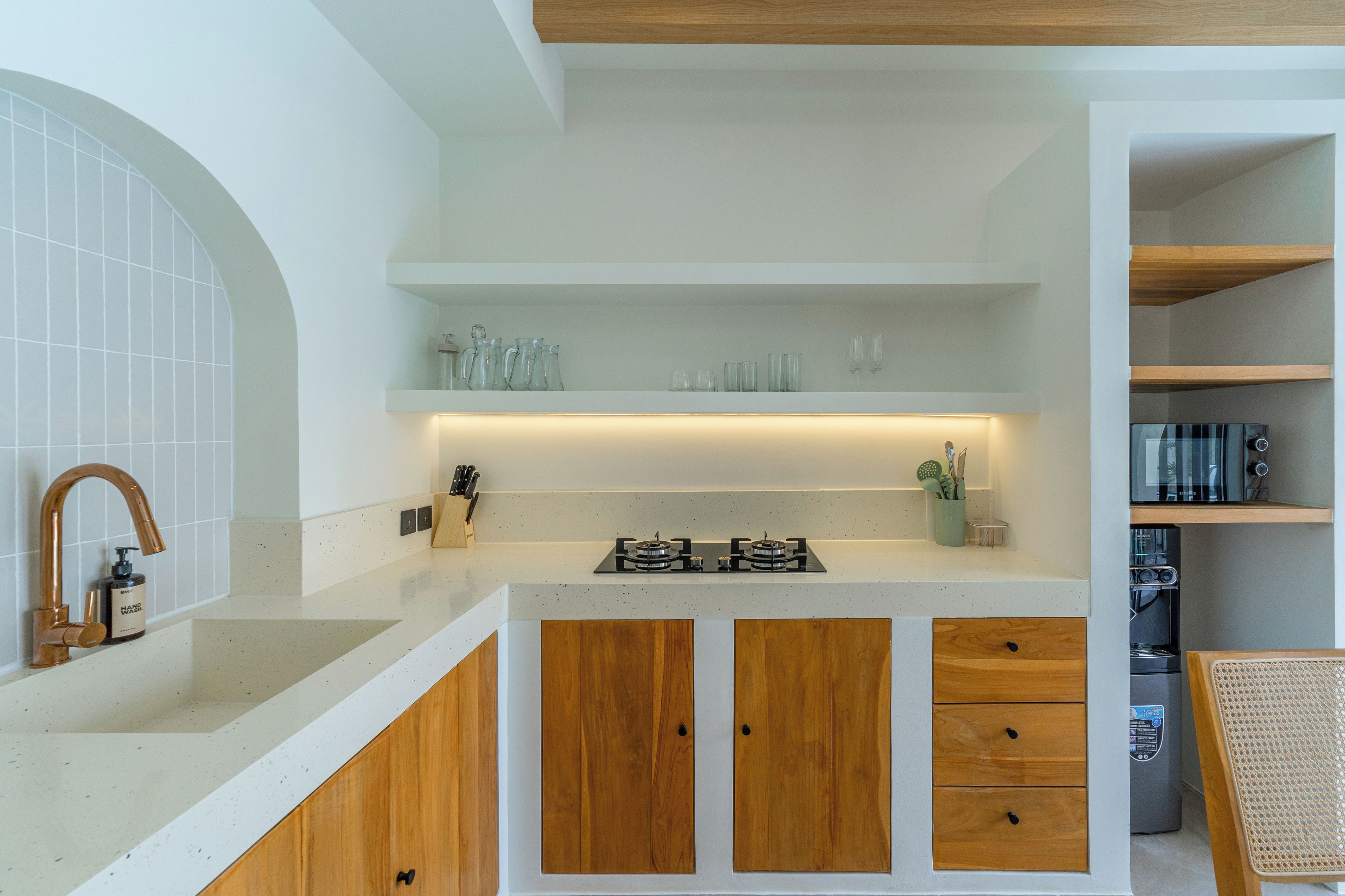 A kitchen with a gas stove, wooden cabinets, and a countertop.