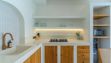 A kitchen with a gas stove, wooden cabinets, and a countertop.