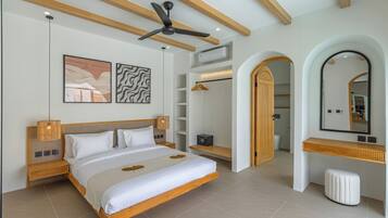 A modern bedroom with a large bed, a ceiling fan, a wardrobe, and a bathroom visible through an archway.