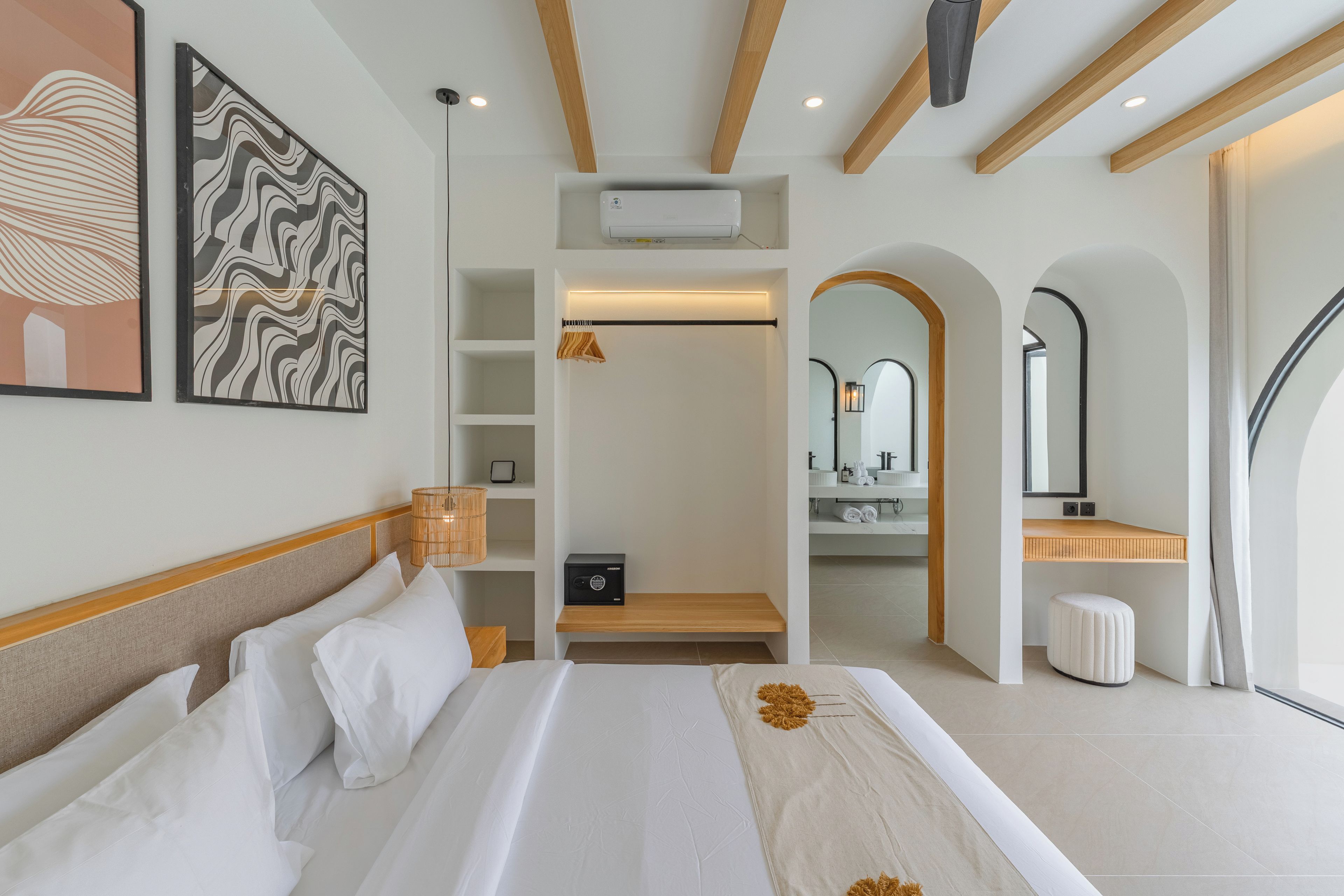 A hotel room with a bed, a walk-in closet, a bathroom with a mirror, and a view of the outdoors.