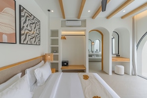 A hotel room with a bed, a walk-in closet, a bathroom with a mirror, and a view of the outdoors. - Villa Solmea Bingin (Bingin)