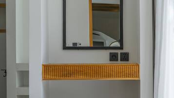 A bathroom with a white vanity, a mirror, and a white stool.