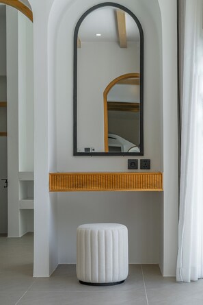 A bathroom with a white vanity, a mirror, and a white stool. - Villa Solmea Bingin (Bingin)
