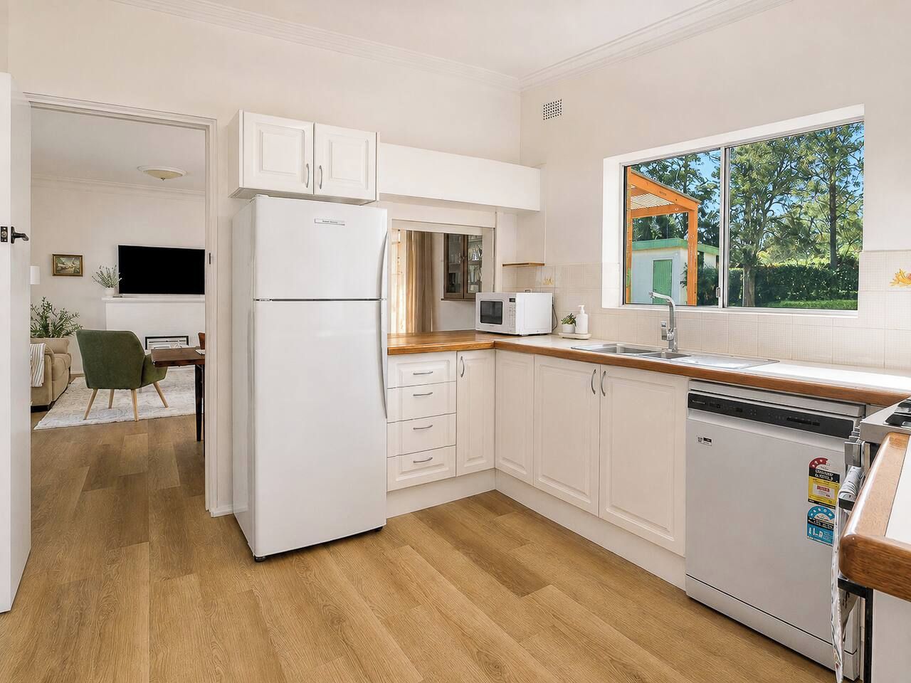 A modern kitchen with white cabinetry, a built-in microwave, and a dishwasher.