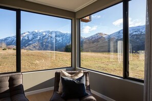 Ein Zimmer mit großen Fenstern und Blick auf die Berge.