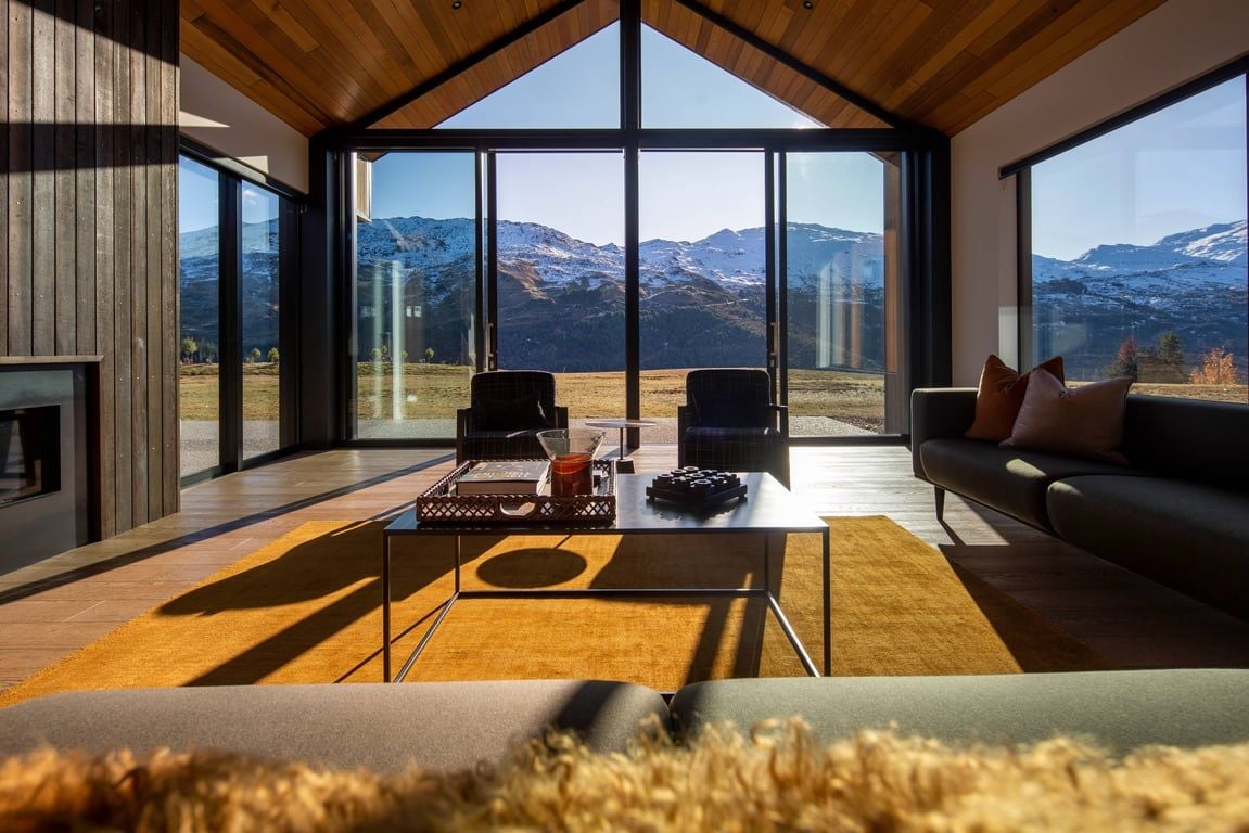 A modern interior with a large window, a sofa, and a coffee table.