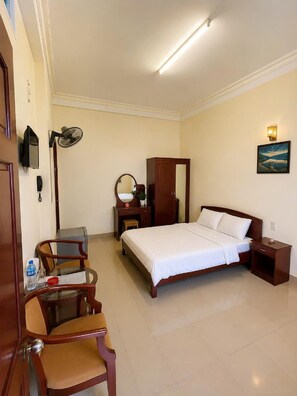 A hotel room with a bed, bedside table, nightstand, desk with chair, and a mirror. - KIM CHI HOTEL (Da Lat)
