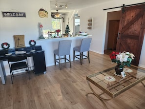 A modern kitchen with a bar area, wooden flooring, and holiday decorations. - 3-bedroom house in peaceful North Port with private pool, minutes from the beach (North Port)