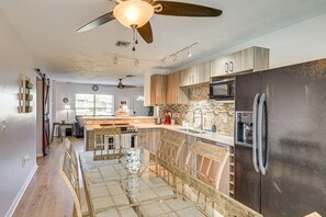 A modern kitchen with a central island, a refrigerator, and a microwave. - 3-bedroom house in peaceful North Port with private pool, minutes from the beach (North Port)